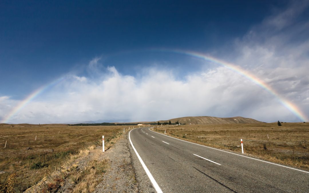 Beautiful full rainbow over road and mountain, New Zealand